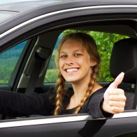 Young woman whit thumb up in a car